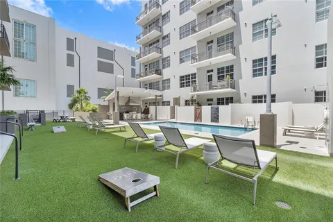 a swimming pool with barbeque oven table and chairs