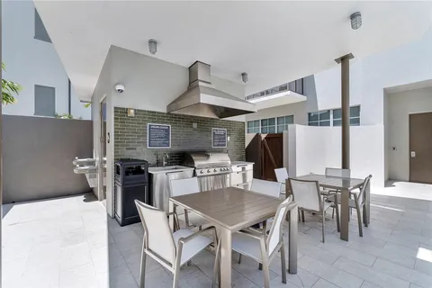 a kitchen with stainless steel appliances kitchen island granite countertop a dining table and chairs