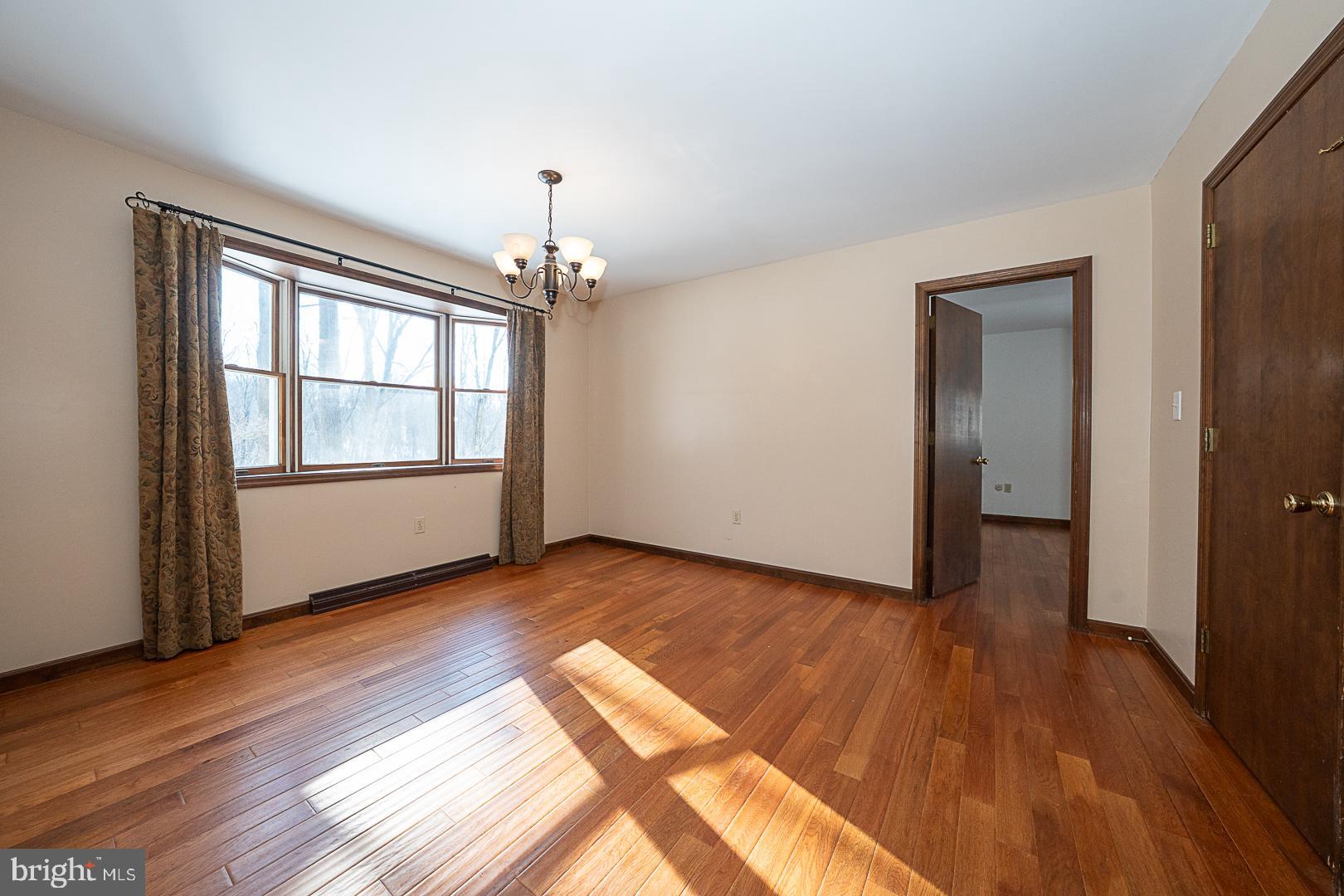 244 South Bonsall Road Coatesville, PA 19320 - Photo 19 of 48 an empty room with wooden floor chandelier and windows