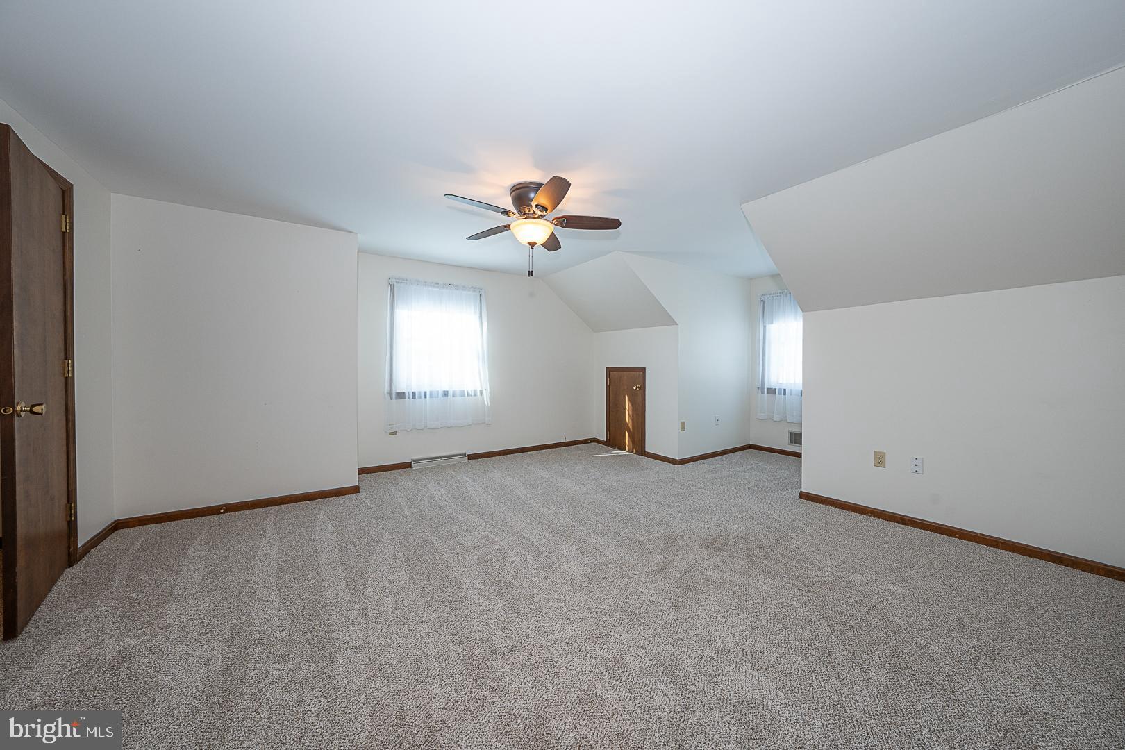 244 South Bonsall Road Coatesville, PA 19320 - Photo 37 of 48 an empty room with chandelier fan and windows