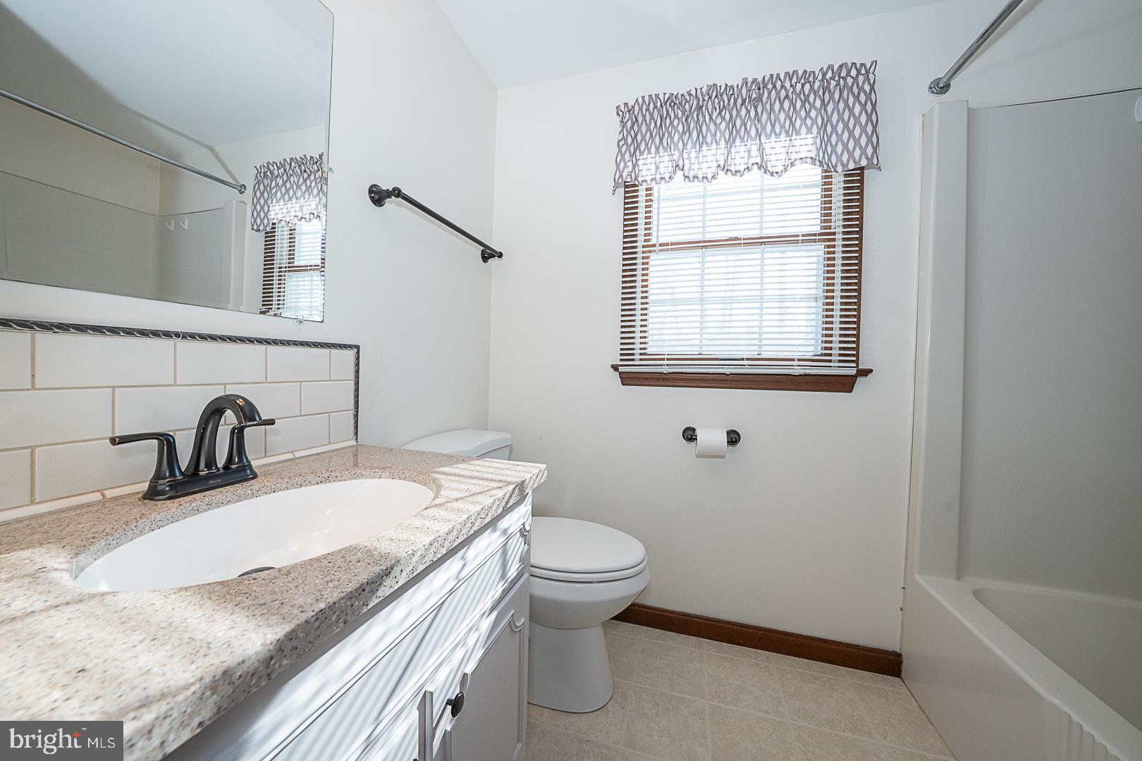 244 South Bonsall Road Coatesville, PA 19320 - Photo 39 of 48 a bathroom with a granite countertop sink toilet and shower
