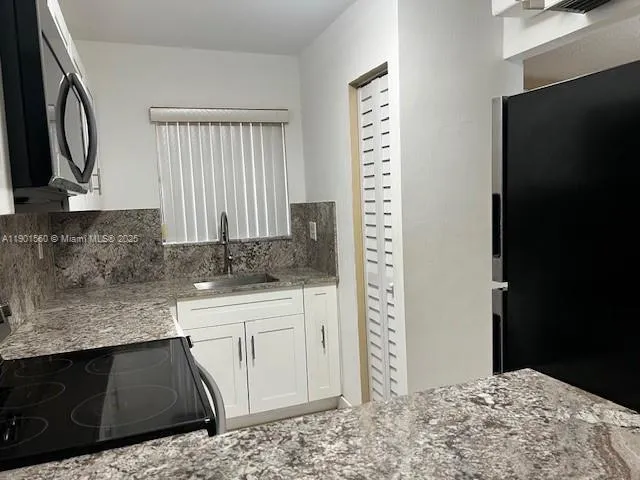a kitchen with a sink and a refrigerator