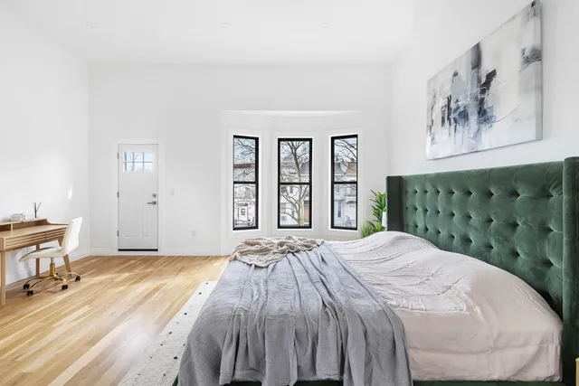 a bedroom with a large bed and a painting on the wall