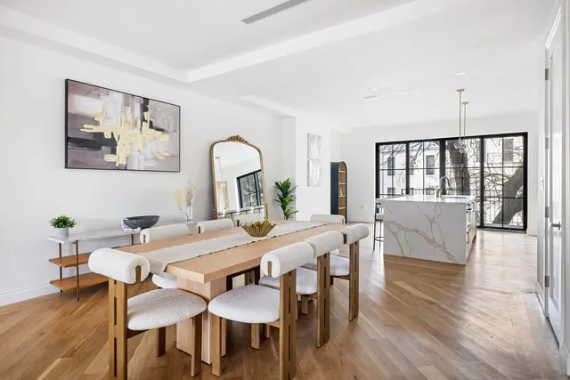 a kitchen with stainless steel appliances granite countertop a refrigerator a stove and white cabinets with wooden floor