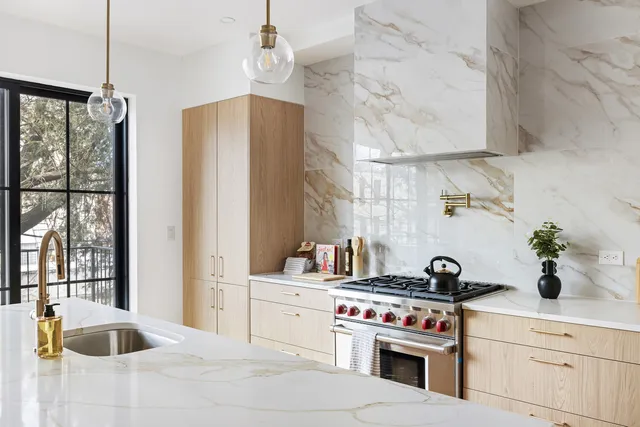 a kitchen with kitchen island a large window cabinets and stainless steel appliances