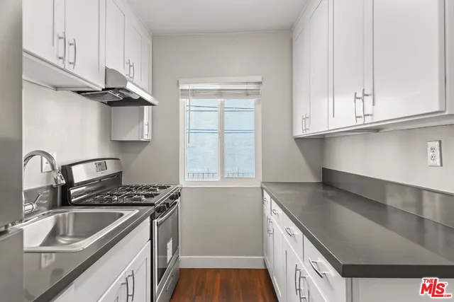 a kitchen with stainless steel appliances granite countertop a sink stove and cabinets