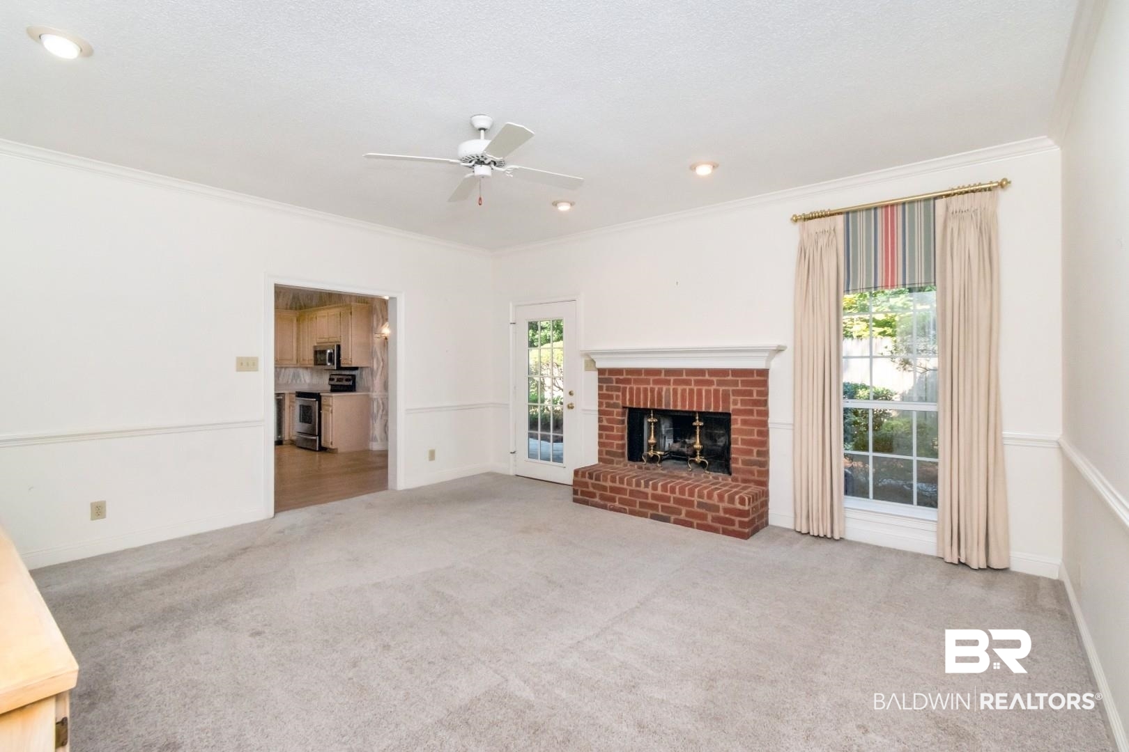 105 McHugh Lane Mobile, AL 36608 - Photo 8 of 30 Unfurnished living room featuring plenty of natural light, light carpet, a brick fireplace, crown molding, and ceiling fan