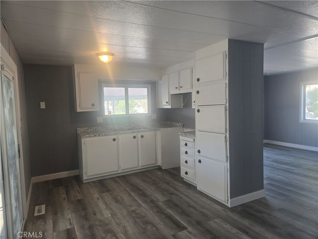 1700 State, Unit 13 Hemet, CA 92543 - Photo 3 of 13 a kitchen with cabinets wooden floor and a window