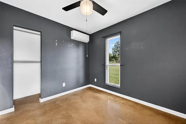 an empty room with windows and closet