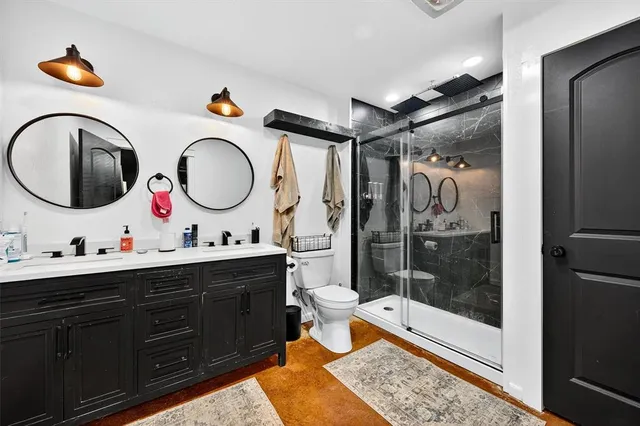 a bathroom with a double vanity sink mirror and shower