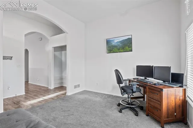 a view of a workspace with furniture and a window