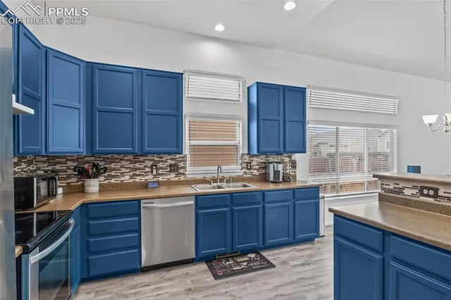 a kitchen with kitchen island wooden cabinets stainless steel appliances a sink and a window