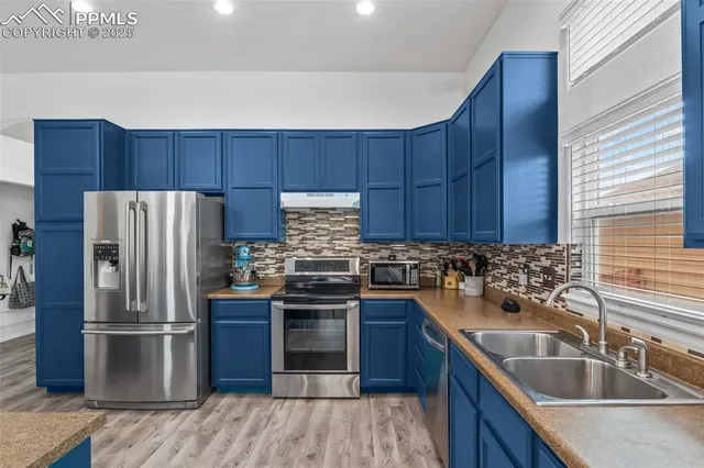 a kitchen with a sink refrigerator and microwave