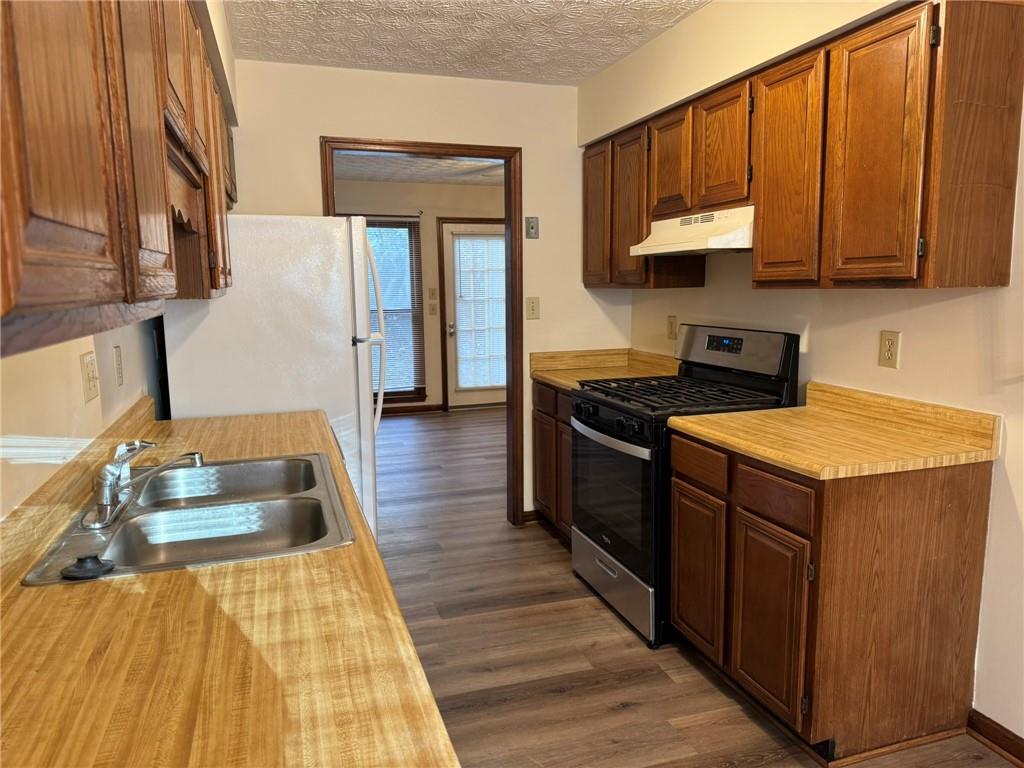 1105 Booth Court Southwest, Unit 1105 Marietta, GA 30008 - Photo 14 of 28 a kitchen with wooden cabinets a sink and a stove