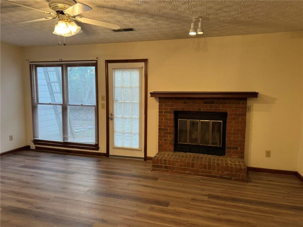 1105 Booth Court Southwest, Unit 1105 Marietta, GA 30008 - Photo 7 of 28 a view of an empty room with wooden floor and a fireplace