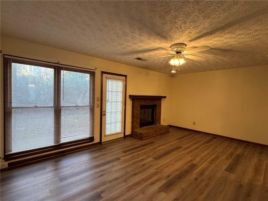1105 Booth Court Southwest, Unit 1105 Marietta, GA 30008 - Photo 10 of 28 an empty room with wooden floor fan and windows