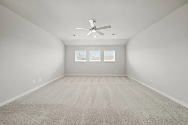 an empty room with a window and a ceiling fan