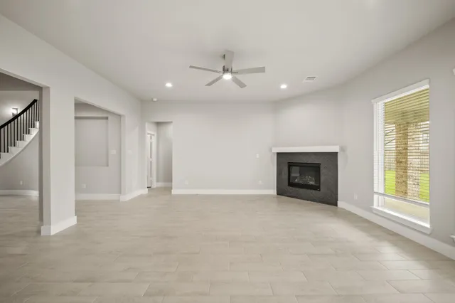 an empty room with windows and fireplace