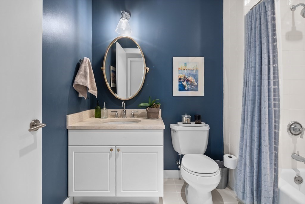 80 Broad Street, Unit 902 Boston, MA 02110 - Photo 16 of 30 a bathroom with a toilet a sink and mirror
