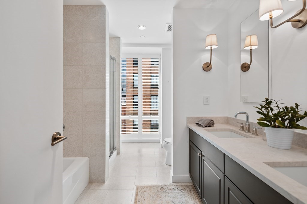 80 Broad Street, Unit 902 Boston, MA 02110 - Photo 10 of 30 a bathroom with a sink a potted plant and a shower