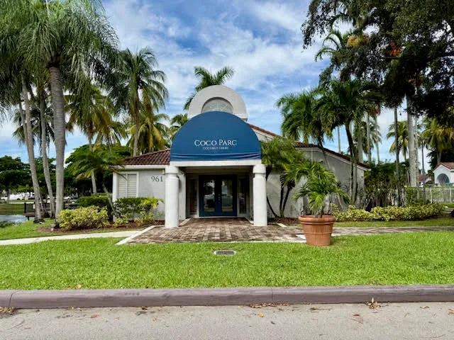 a view of a house with a yard and large tree