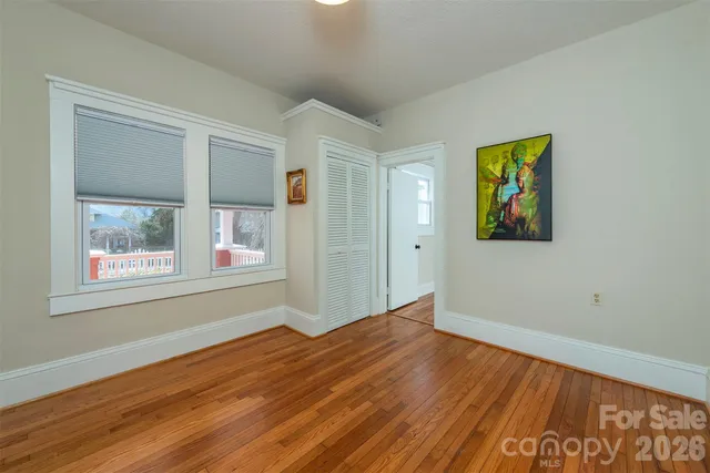 a view of empty room with wooden floor and wall painting