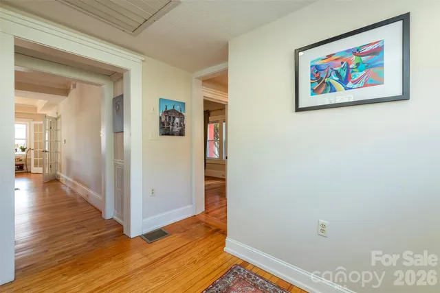 a view of a hallway with wooden floor and closet