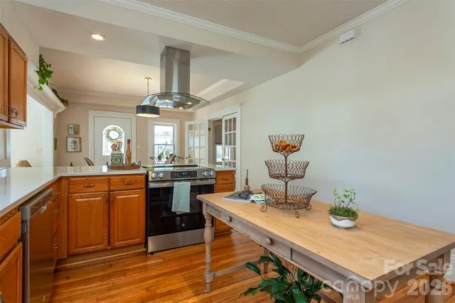 a kitchen with stainless steel appliances a dining table and chairs