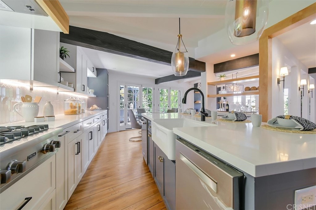 a large kitchen with kitchen island a large counter space a sink and wooden floor