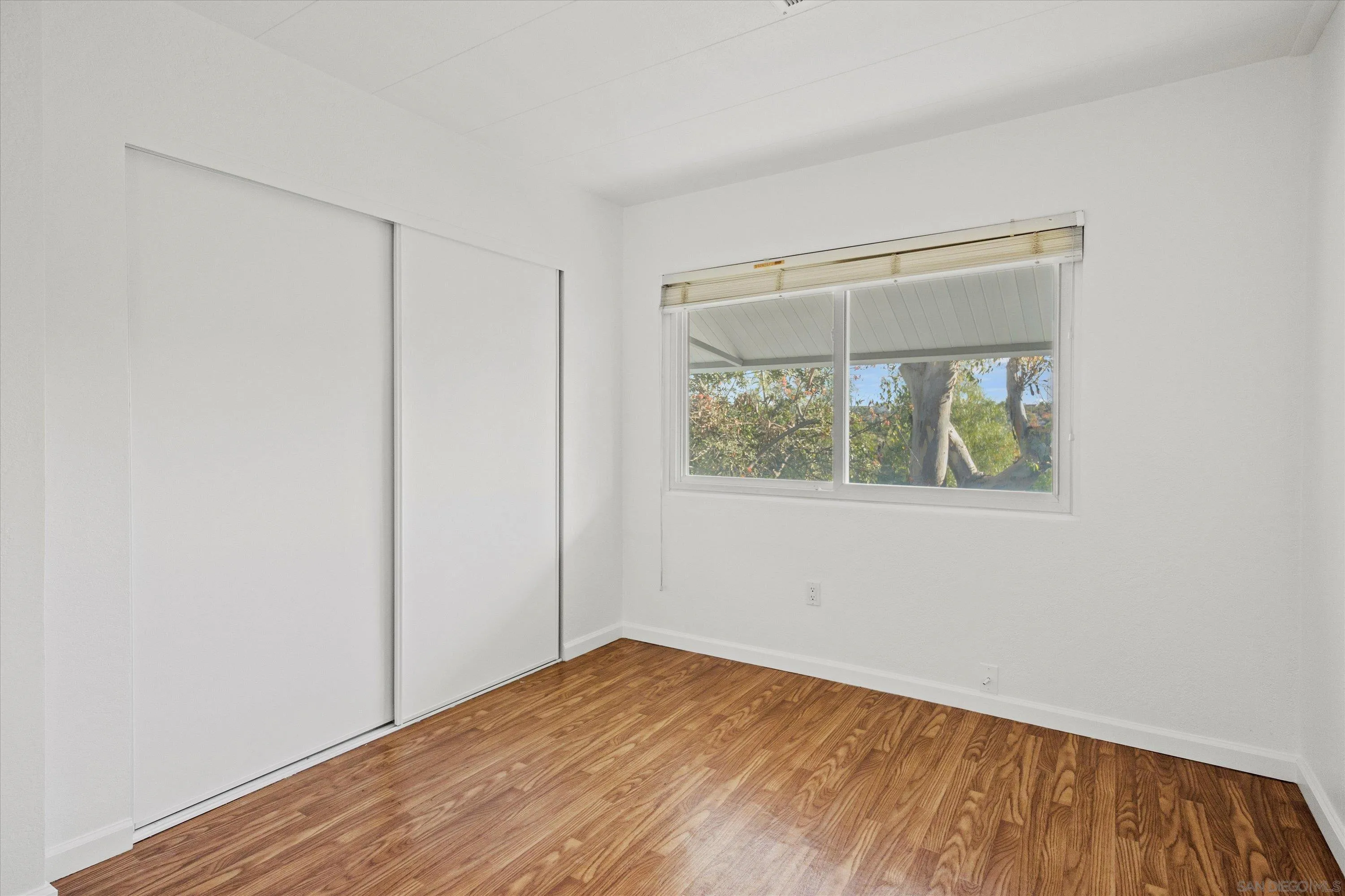 1925 Otay Lakes Road Chula Vista, CA 91913 - Photo 15 of 27 a view of an empty room with wooden floor and a window