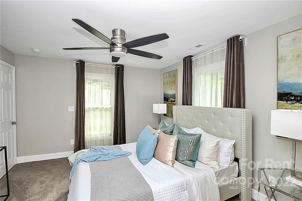 824 South Ridge Avenue, Unit 4 Kannapolis, NC 28083 - Photo 10 of 30 a bedroom with a large bed and a chandelier