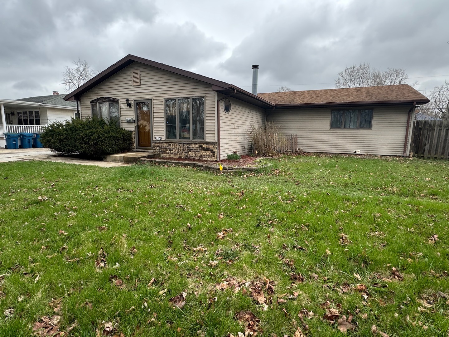 a view of a house with a yard plants and large tree