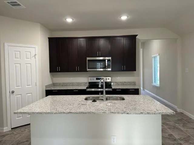 a kitchen with stainless steel appliances granite countertop a sink and a microwave