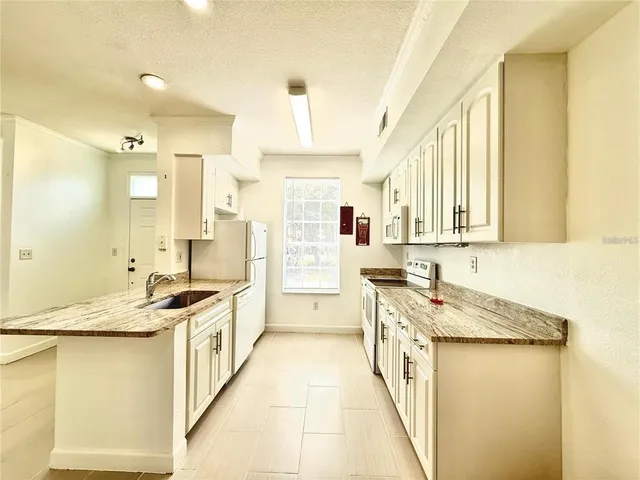 a kitchen with stainless steel appliances granite countertop a sink and a stove top oven