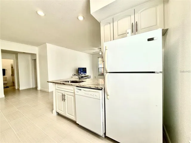 a kitchen with stainless steel appliances granite countertop a refrigerator and a stove