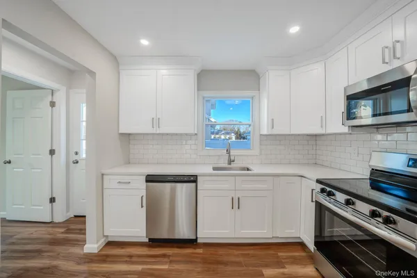 a kitchen with stainless steel appliances a stove microwave and sink