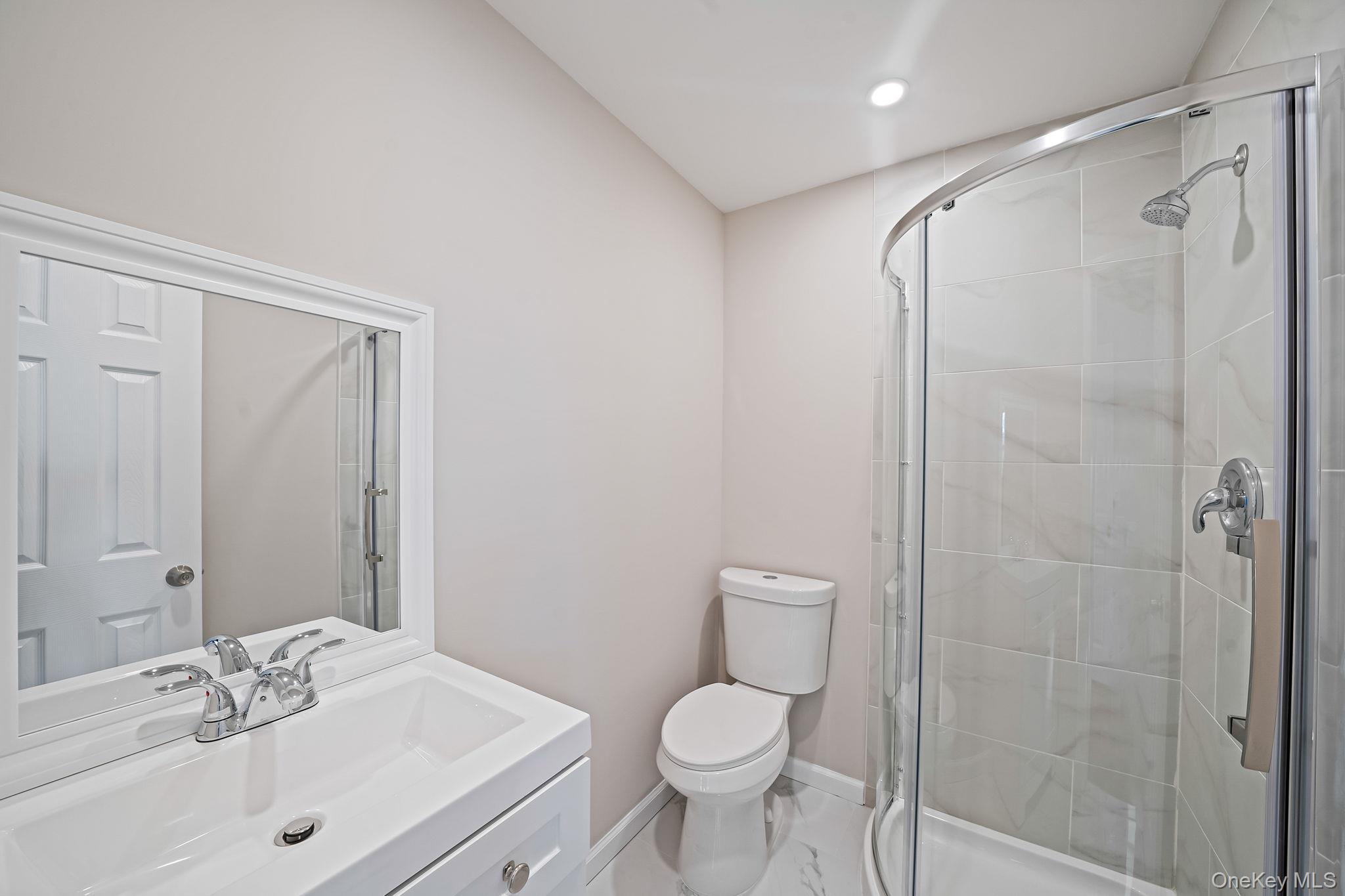 247 Rider Avenue Patchogue, NY 11772 - Photo 23 of 25 a bathroom with a sink toilet and shower