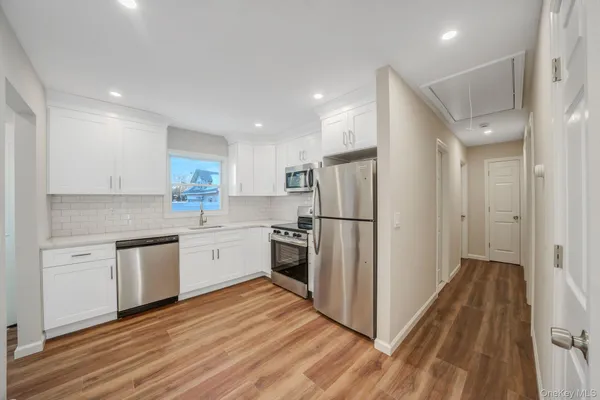 a kitchen with white cabinets and stainless steel appliances