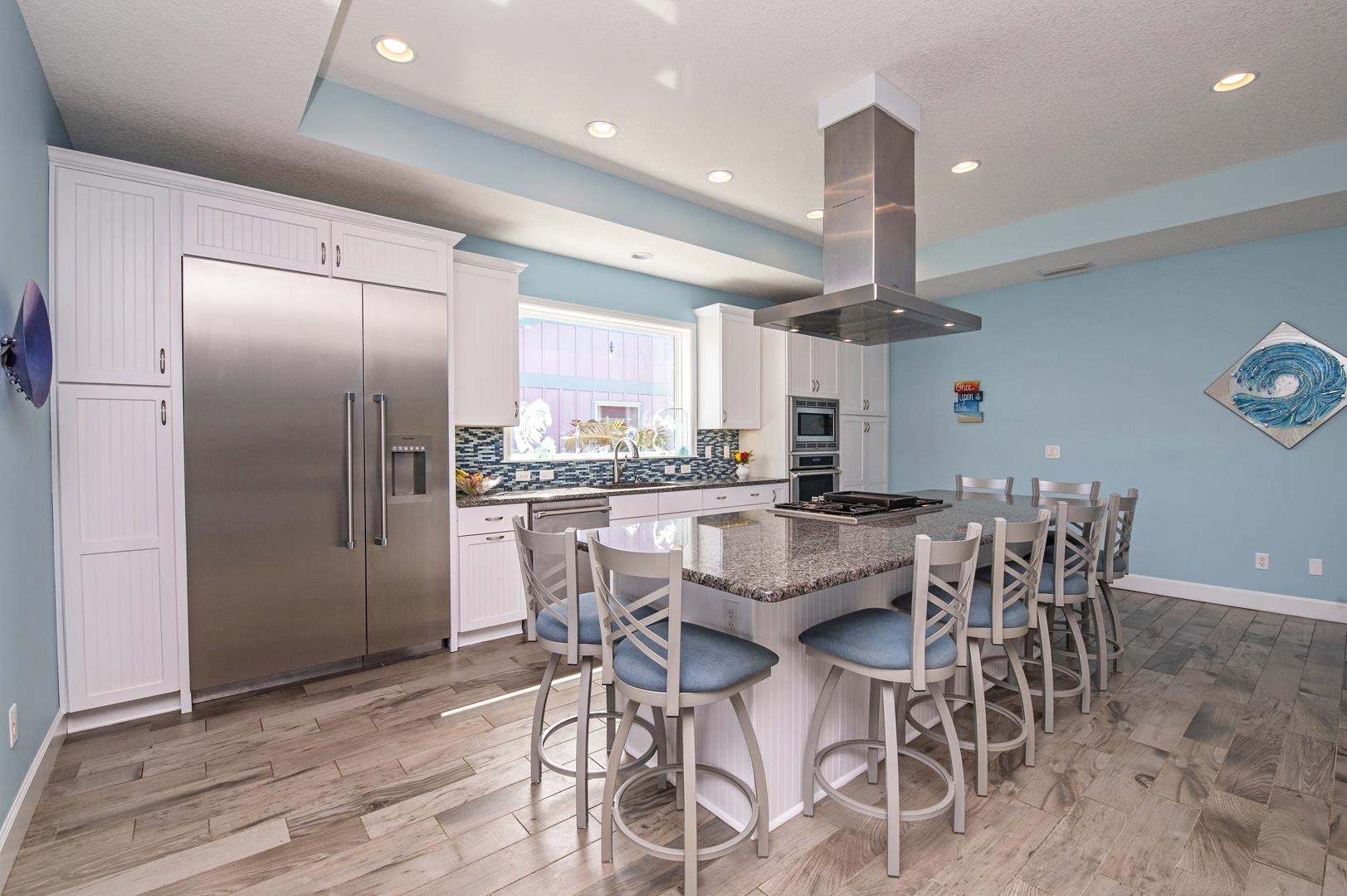 6056 Costanero Road St. Augustine, FL 32080 - Photo 6 of 30 Kitchen with built in appliances, white cabinetry, island exhaust hood, a center island, and backsplash