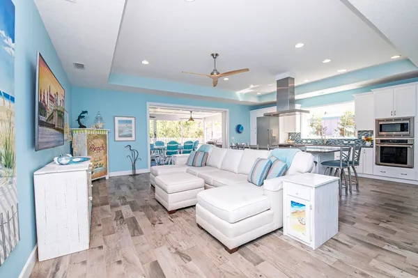 a living room with furniture a flat screen tv and kitchen view