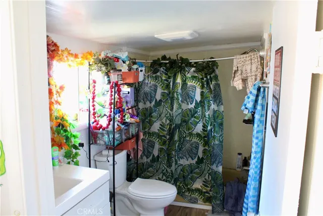 a bathroom with a toilet sink and shower curtain