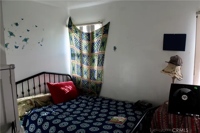 a bedroom with a bed and a flat tv screen on a dresser