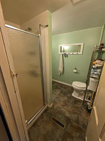 a bathroom with a granite countertop shower and a toilet