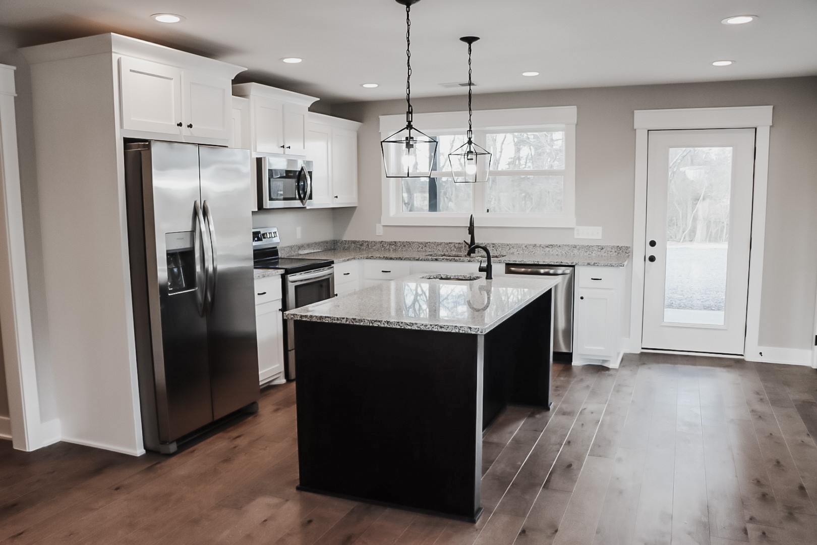 4184 Oregon Road Springfield, TN 37172 - Photo 19 of 33 a large kitchen with a center island wooden floor stainless steel appliances and a window