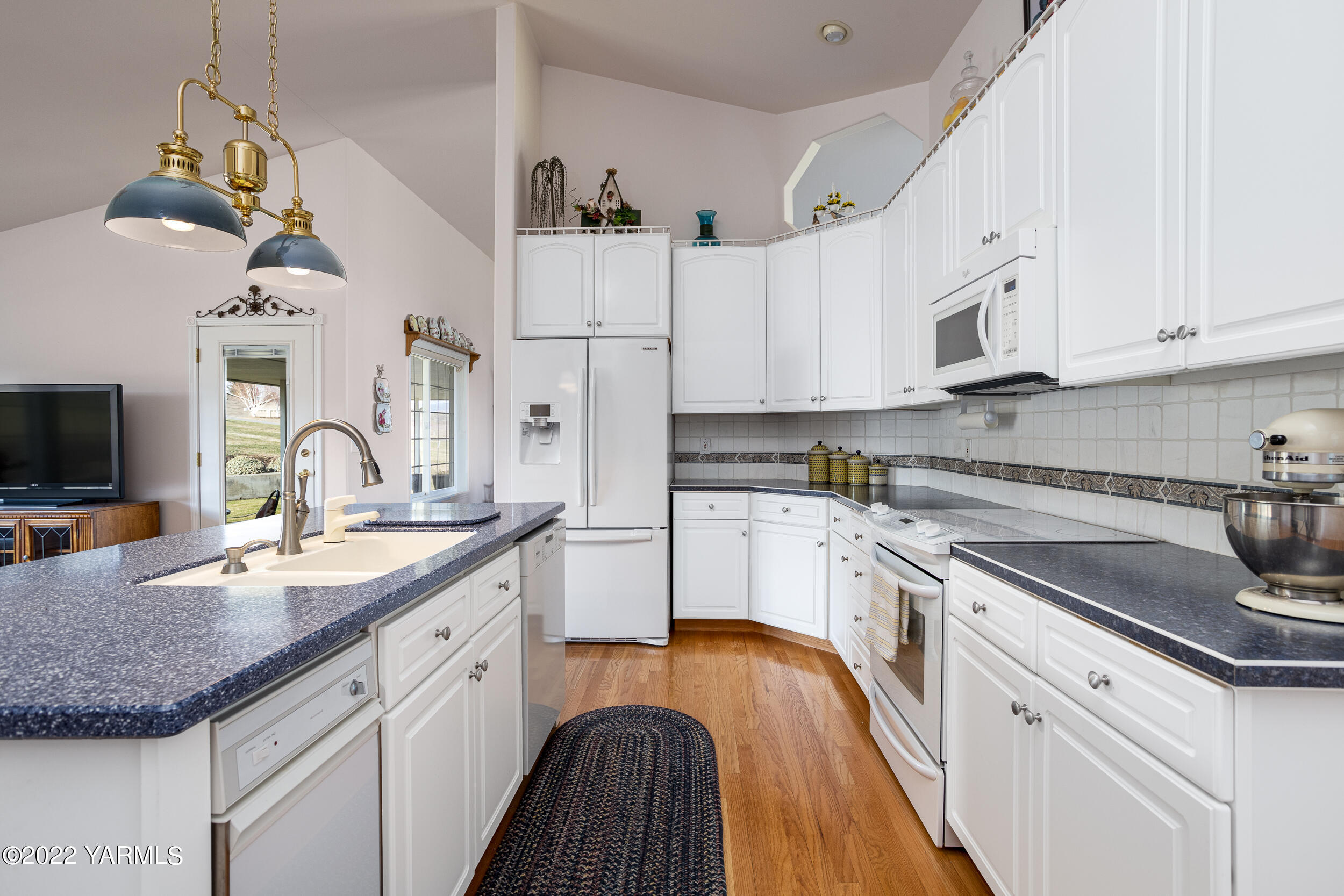 200 Nash Road Tieton, WA 98947 - Photo 12 of 29 a kitchen with stainless steel appliances granite countertop a sink dishwasher and white cabinets with wooden floor
