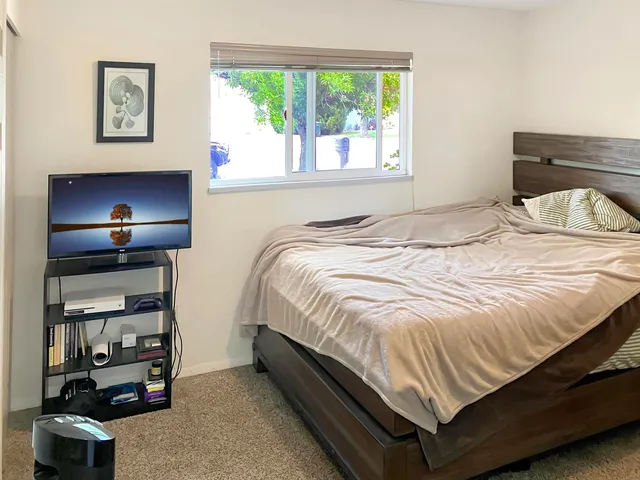 a bed sitting in a bedroom next to a window