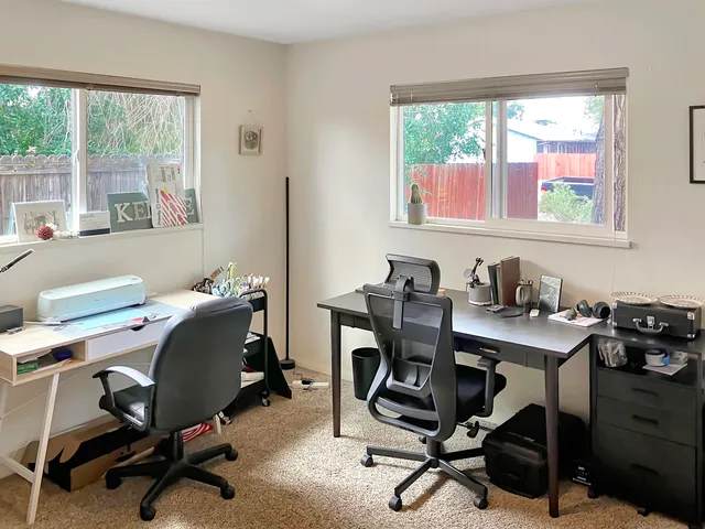 a view of a workspace with furniture and a window
