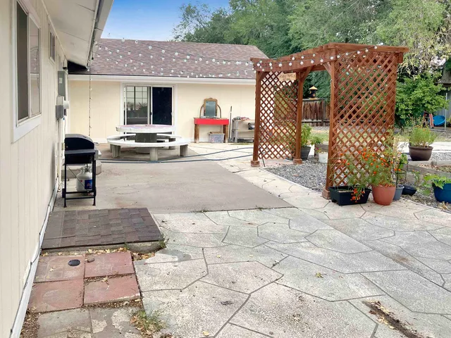 a view of a patio with table and chairs potted plants