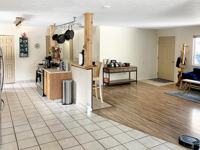 a kitchen with stainless steel appliances kitchen island granite countertop a stove a sink and white cabinets with wooden floor