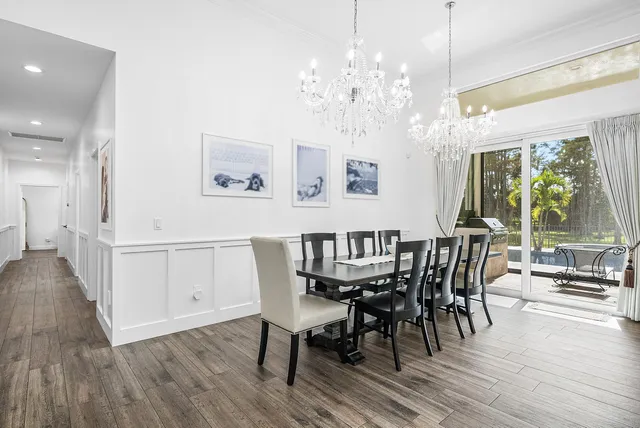 a view of a livingroom with furniture wooden floor windows and a chandelier
